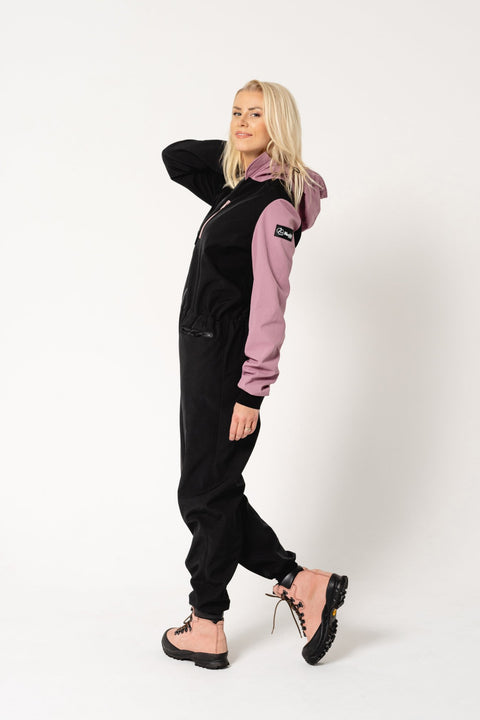 3. Women's Eeva softshell overall by Nuckö in black and pink, side view in a studio setting