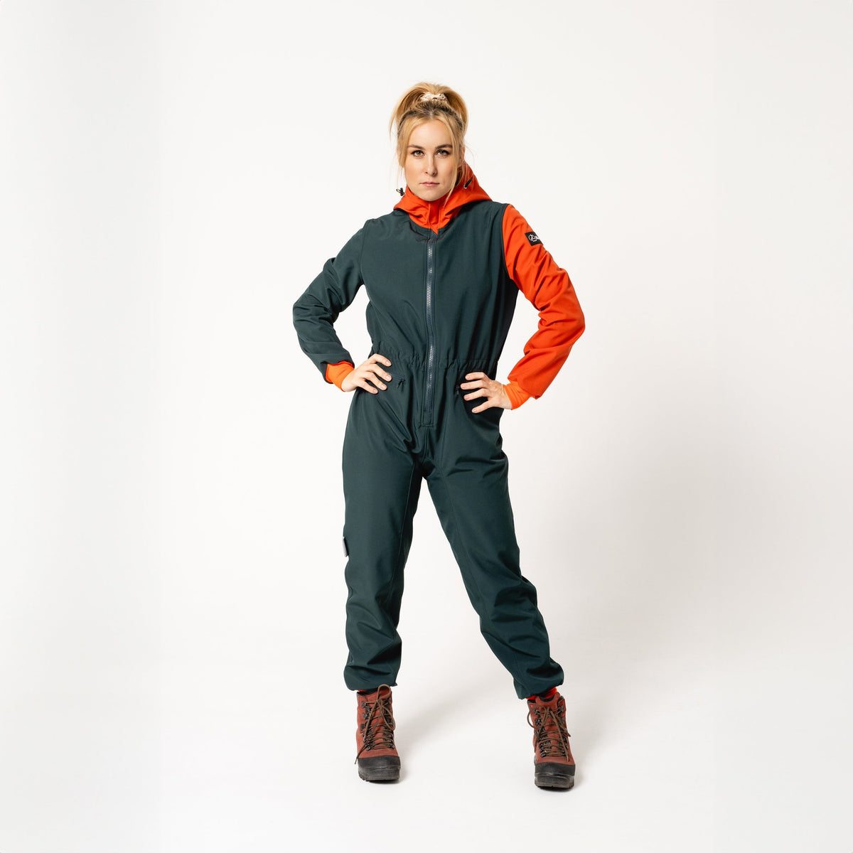 3. Women's Kristel softshell overall by Nuckö in dark green and orange, full front view in studio