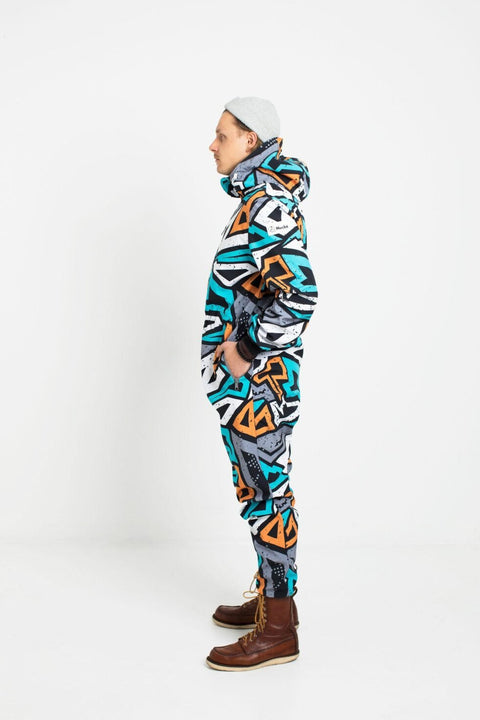 2. Side view of man in Nuckö TANIEL softshell overall with adjustable hood and waist, geometric pattern, studio background