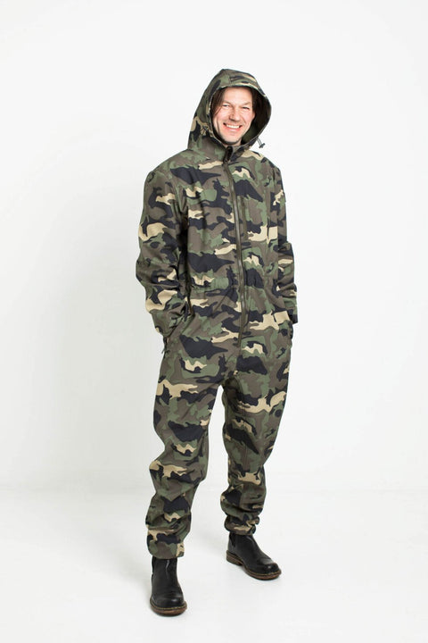 4. Man smiling in Nuckö RINGO softshell overall with hood up in camouflage pattern in studio