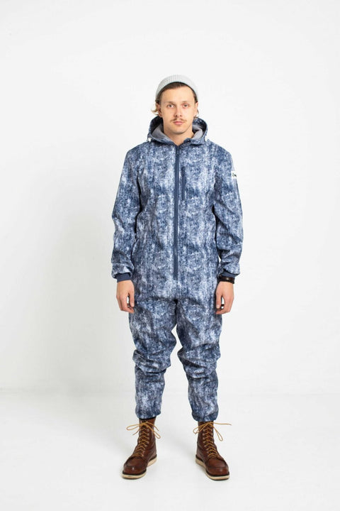 1. Man wearing Nuckö ERGO softshell overall with blue digital print, standing in studio with hands by sides