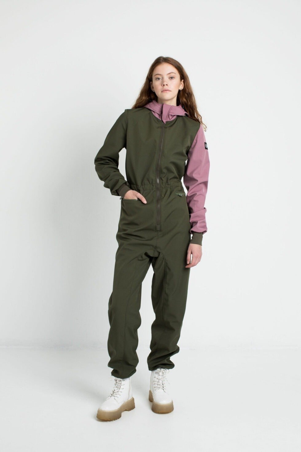 2. Side view of women's KERTTU softshell overall by Nuckö in green and pink, studio setting