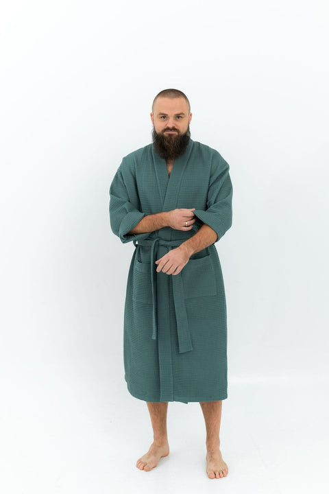 5. Man wearing green waffle fabric robe with belt and side pockets standing on white background