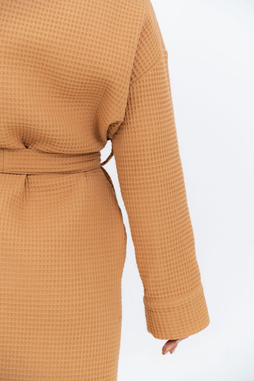 8. Close-up of back of orange waffle robe with belt, studio background