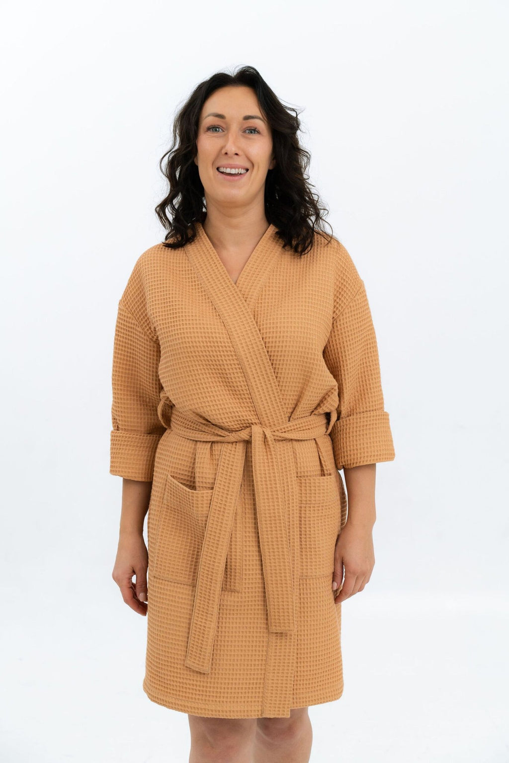 3. Woman in orange waffle robe with belt and side pockets, smiling in studio