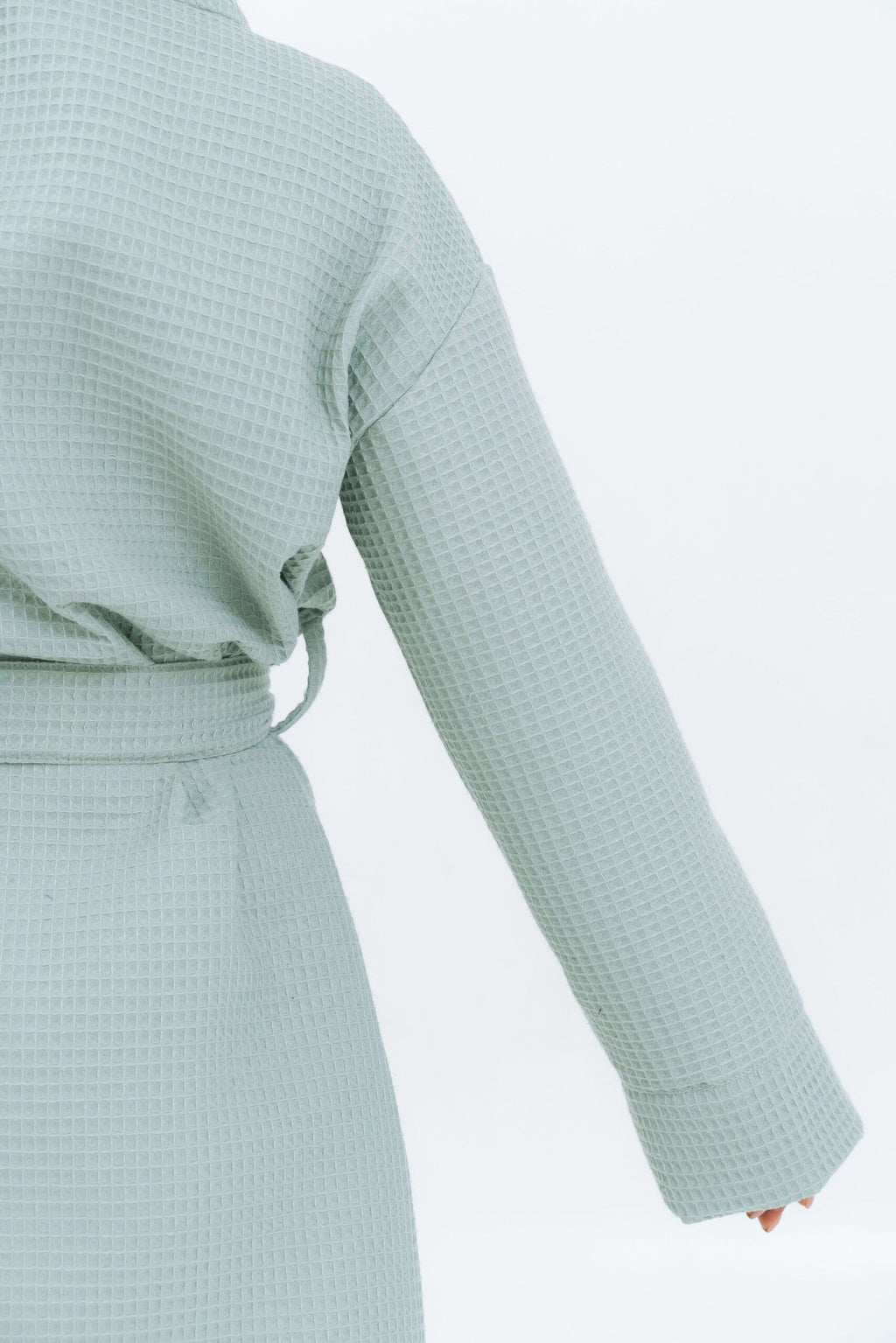 3. Close-up of sleeve and back of light green waffle fabric robe, showing texture