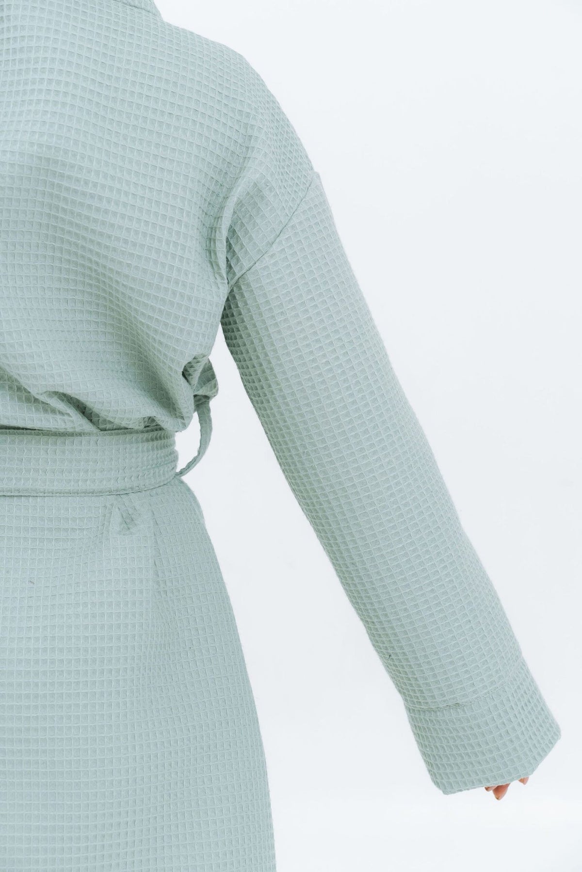 3. Close-up of sleeve and back of light green waffle fabric robe, showing texture