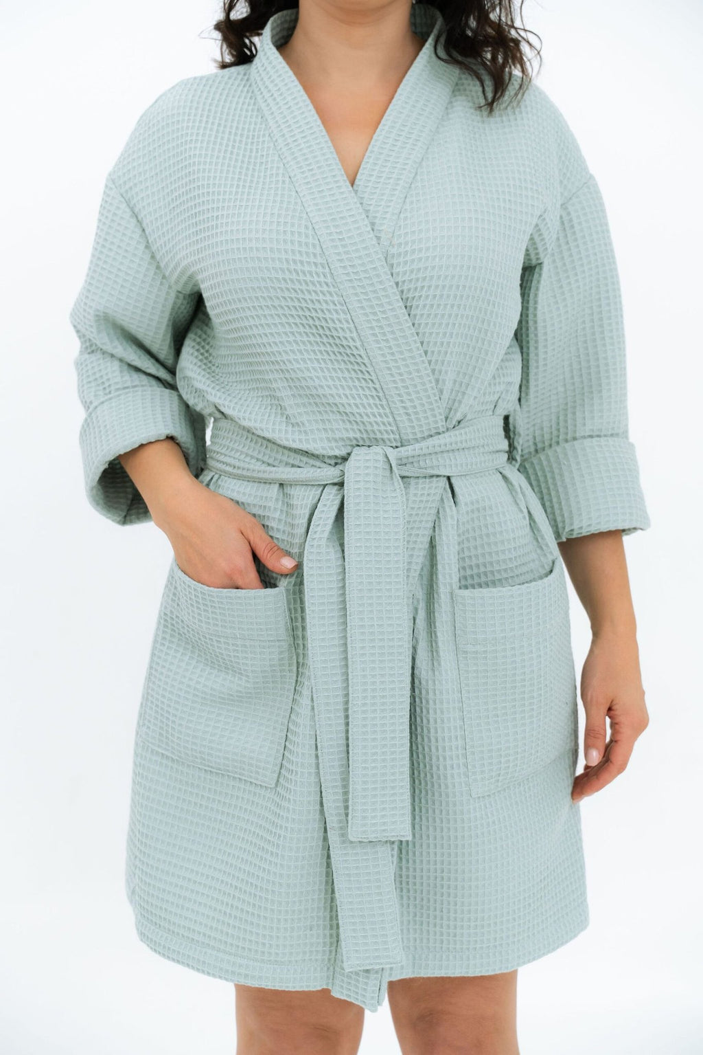 2. Woman in light blue waffle robe with belt and side pockets, studio background