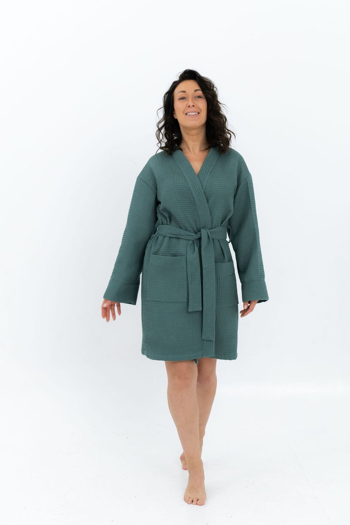 9. Woman in green waffle robe with belt and side pockets, walking in studio