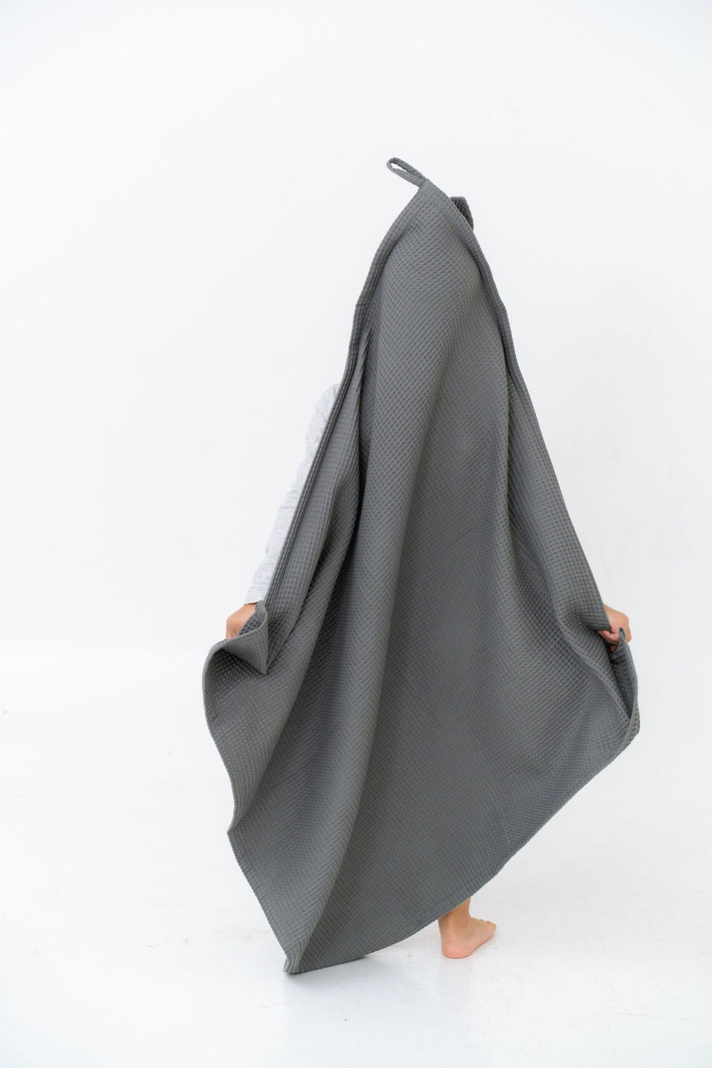 6. Child holding up large gray waffle fabric towel with bunny ears hood