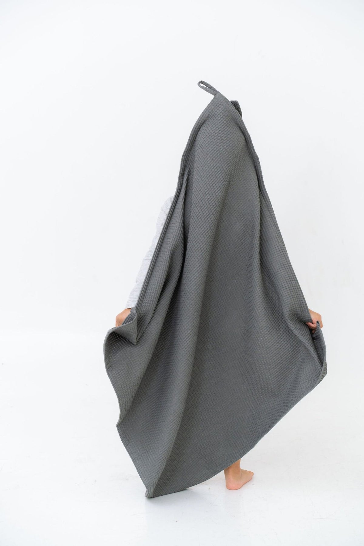6. Child holding up large gray waffle fabric towel with bunny ears hood