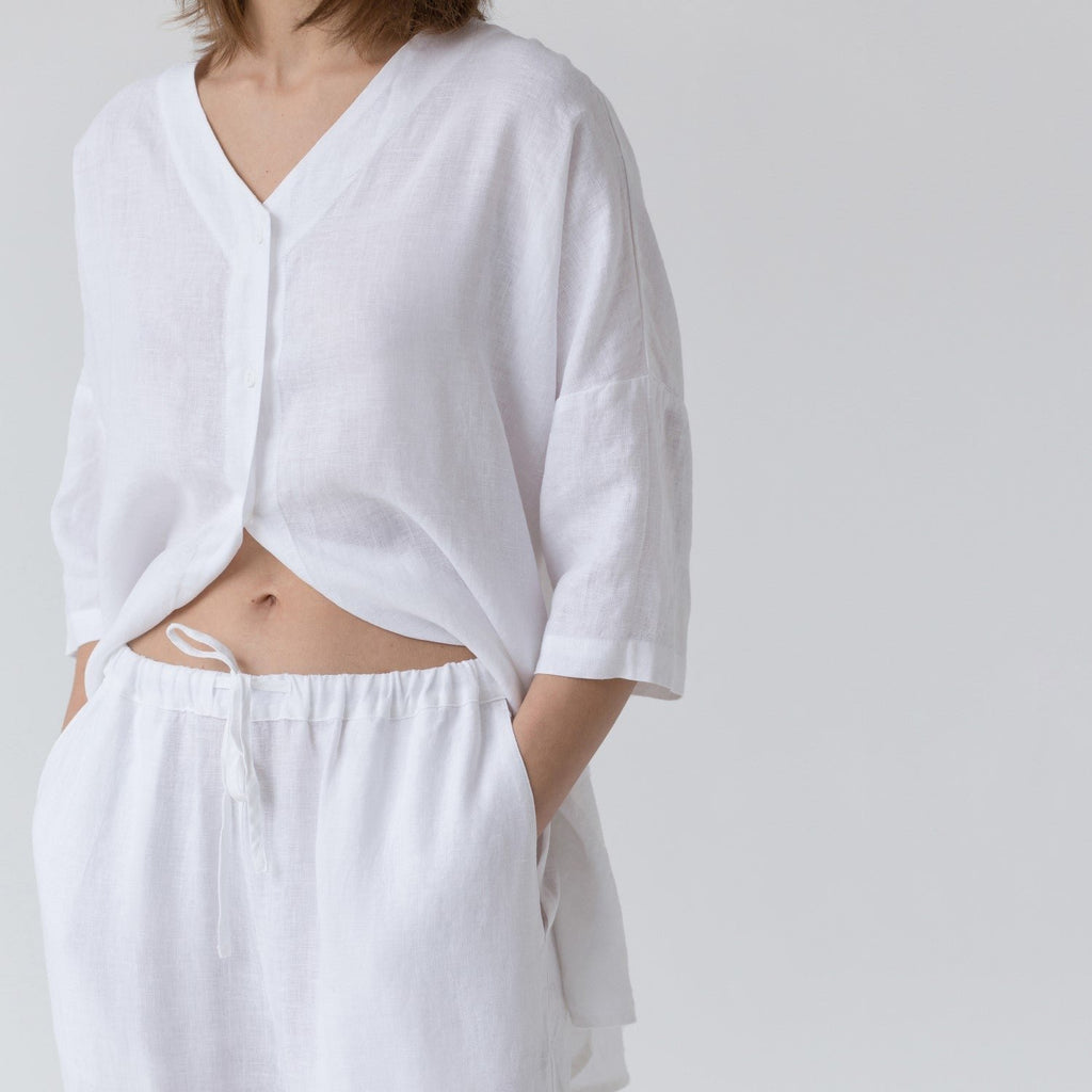 6. Close-up of optical white linen loungewear set showing V-neck shirt and elasticated waistband with drawstring