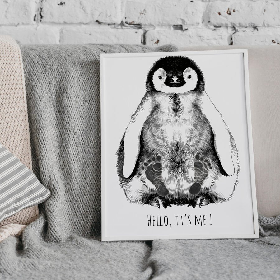 1. Personalized baby penguin footprint kit in white A4 frame with hand-drawn penguin illustration and text 'Hello, it's me!' displayed on a cozy sofa with textured blankets.