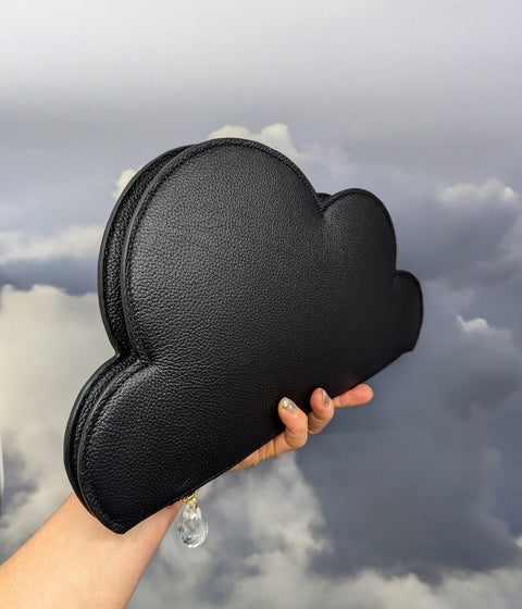 5. Tairi Roosve Leather Clutch Bag Cloud in black held against a cloudy sky background, emphasizing design and raindrop detail