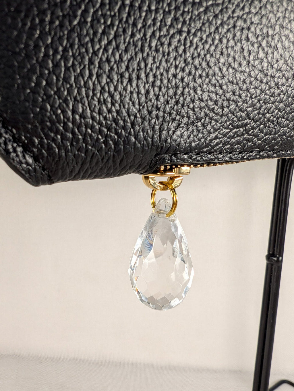 8. Close-up of raindrop detail on Tairi Roosve Leather Clutch Bag Cloud in black, showcasing premium Excella zip