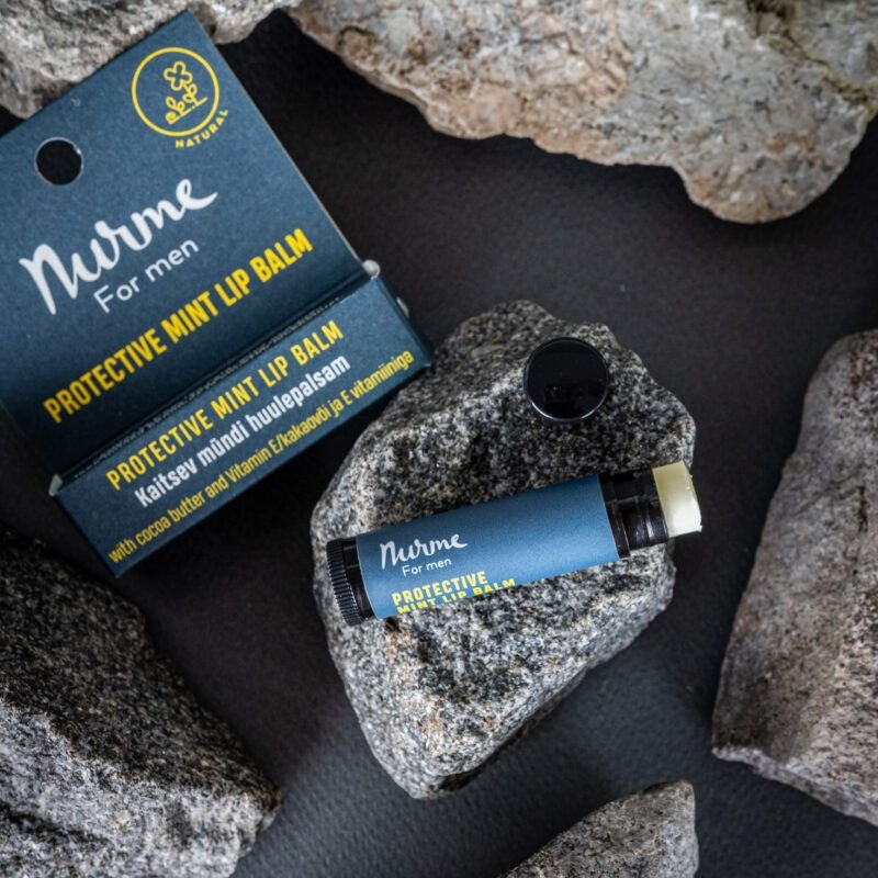 7. Close-up of Nurme Protective Mint Lip Balm on rocks, showcasing packaging and natural elements
