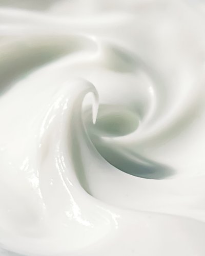 3. Woman applying Nurme Neroli Hydrating Day Cream while looking in mirror