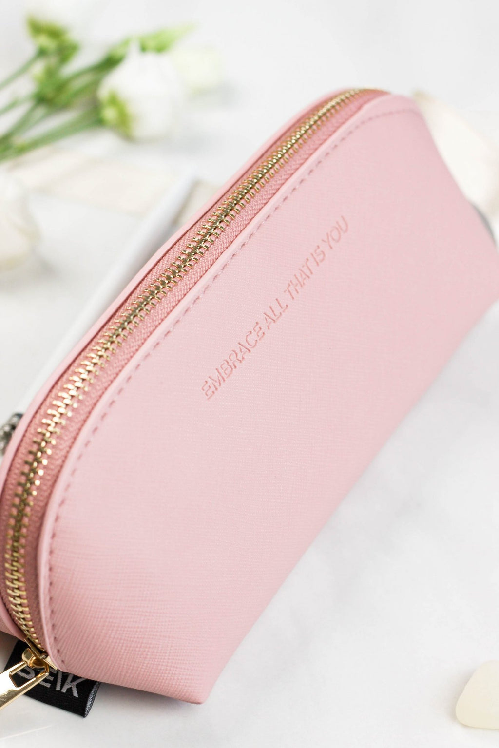 5. SEIK pink pencil case with embossed phrase 'EMBRACE ALL THAT IS YOU', shown in a lifestyle setting