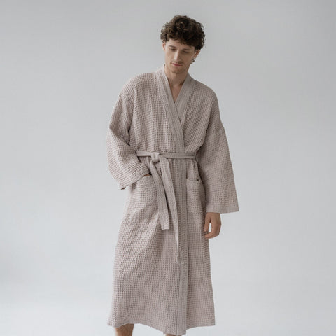 5. Man wearing powder-colored honeycomb waffle bathrobe with waist tie and pockets, standing in a studio
