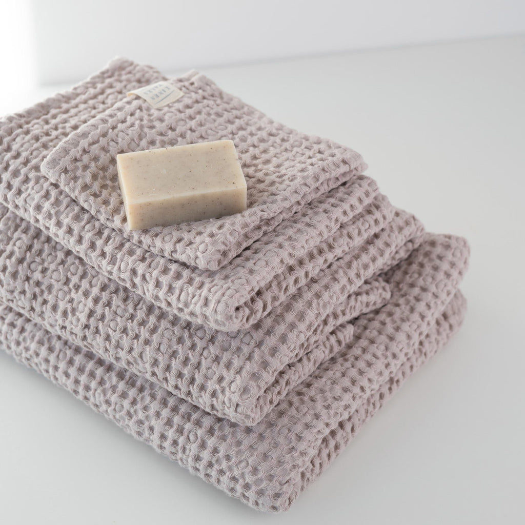 3. Powder-colored honeycomb waffle towels stacked with a soap bar, showcasing texture and weave