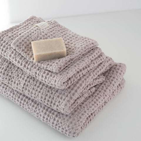 3. Powder-colored honeycomb waffle towels stacked with a soap bar, showcasing texture and weave