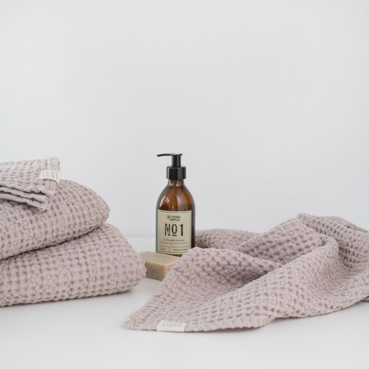 7. Powder-colored honeycomb waffle towels with soap and lotion bottle, highlighting texture and color