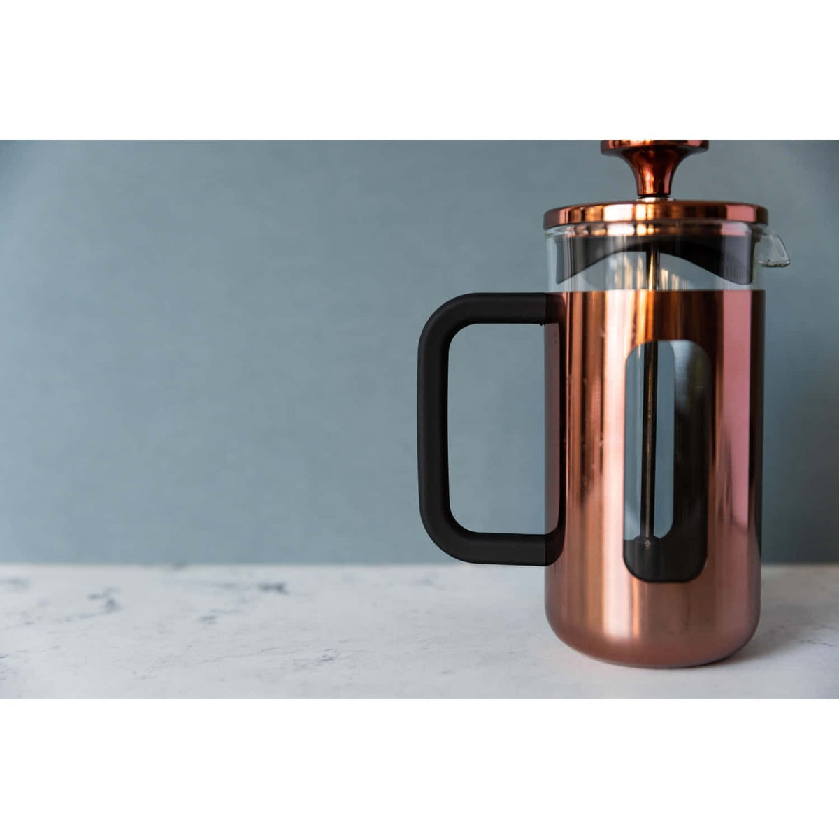 4. Lifestyle shot of La Cafetière Pisa coffee maker in copper on marble surface with blue background