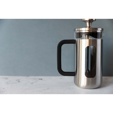 1. La Cafetière Pisa Coffee Maker in silver with black handle on marble surface against blue wall