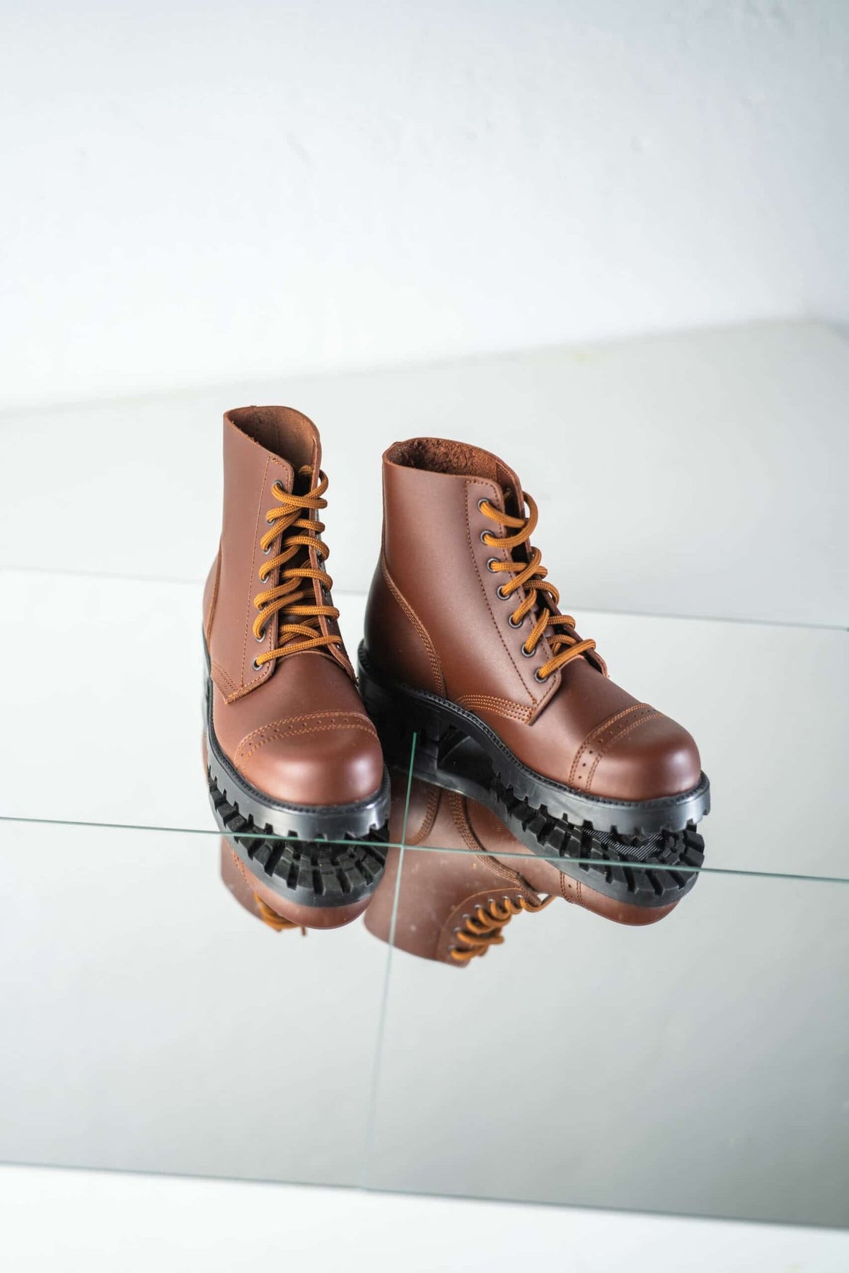 4. Pair of unisex brown Samelin 517 Aviator Boots on reflective surface, emphasizing design and grip