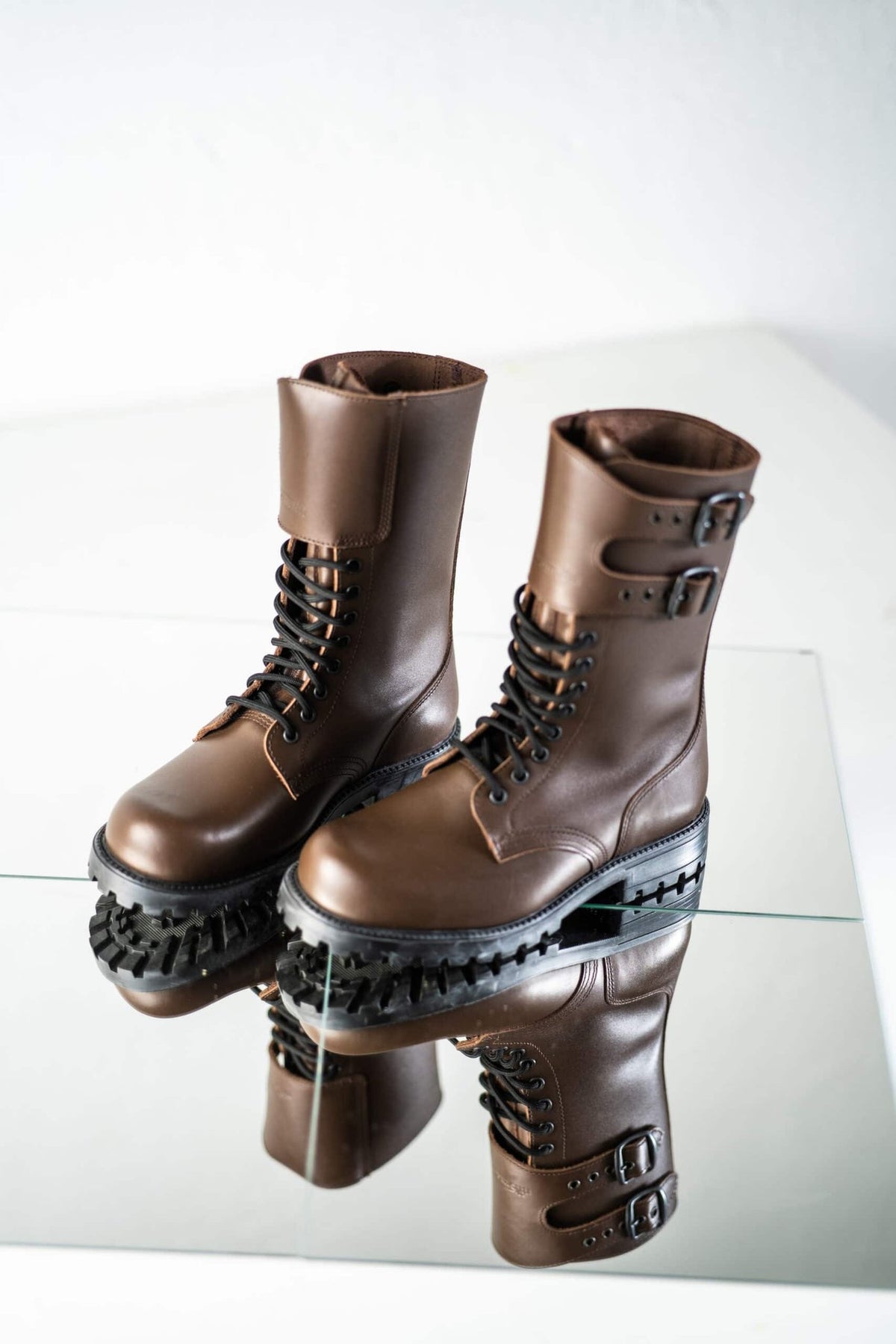 7. Unisex Tarkovsky Boots in dark brown leather, shown from side angle on reflective surface