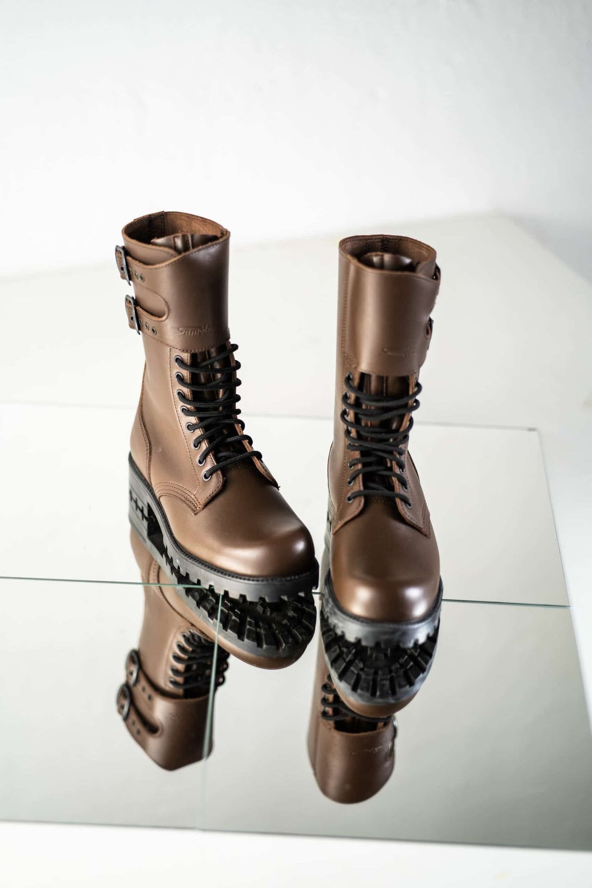 4. Pair of unisex Tarkovsky Boots in dark brown leather, displayed on reflective surface
