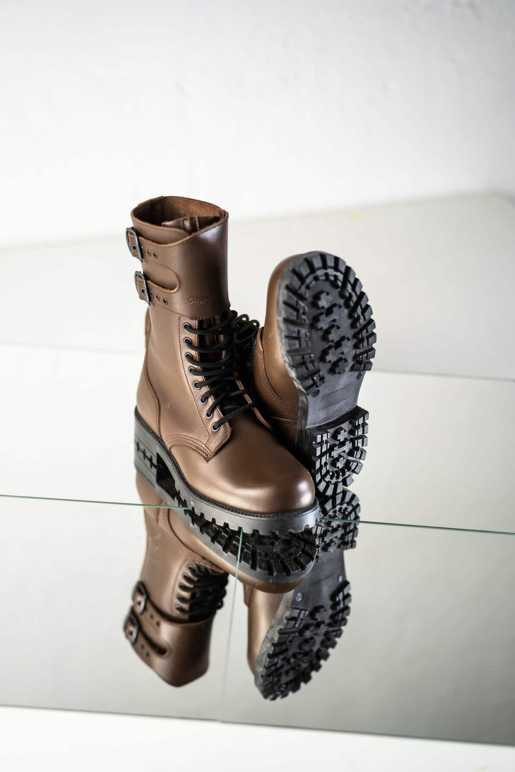 5. Unisex Tarkovsky Boots in dark brown leather, showing tread pattern on sole, displayed on reflective surface