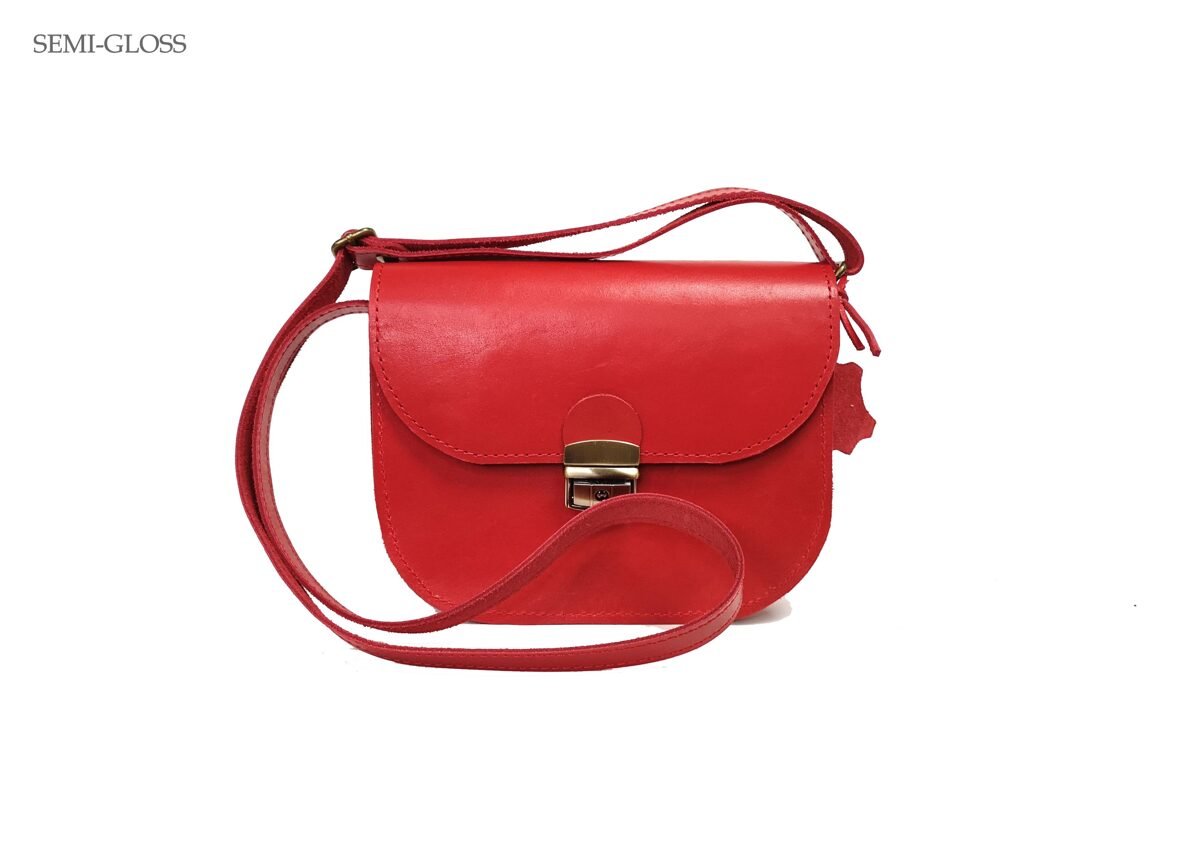 5. Studio shot of Zelma Kraft red leather saddle bag, highlighting semi-gloss finish and adjustable strap