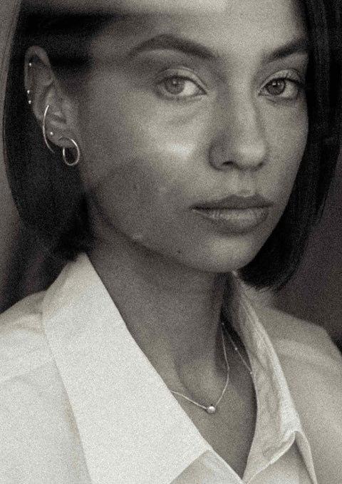 2. Close-up of woman wearing NO MORE Radius earrings in silver, highlighting minimalist style