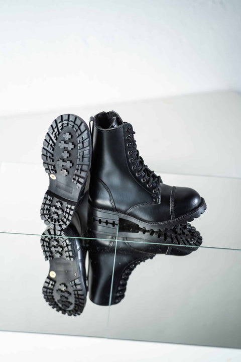 4. Unisex black 511 Winter boots by Samelin on reflective surface, showing tread pattern and leather upper