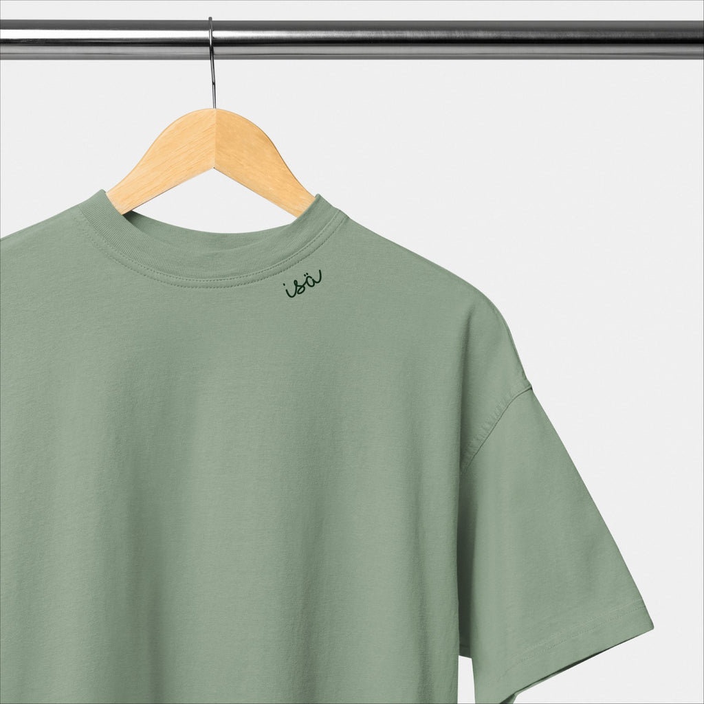 2. Green unisex organic cotton t-shirt with embroidered collar by Beebila, hanging on a wooden hanger