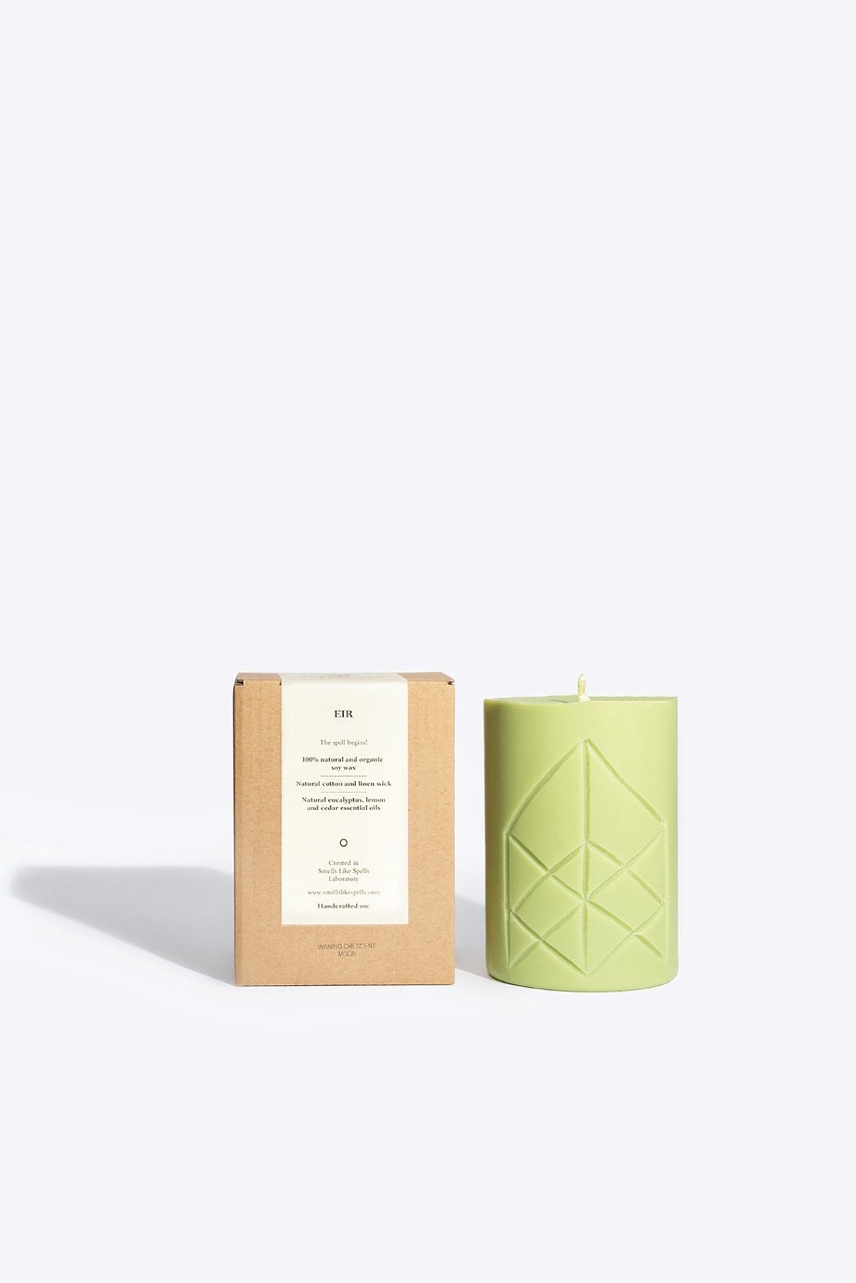 2. Smells Like Spells Rune Candle EIR in light green with packaging, studio setting