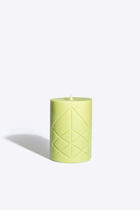 3. Smells Like Spells Rune Candle EIR in light green with rune design, studio setting