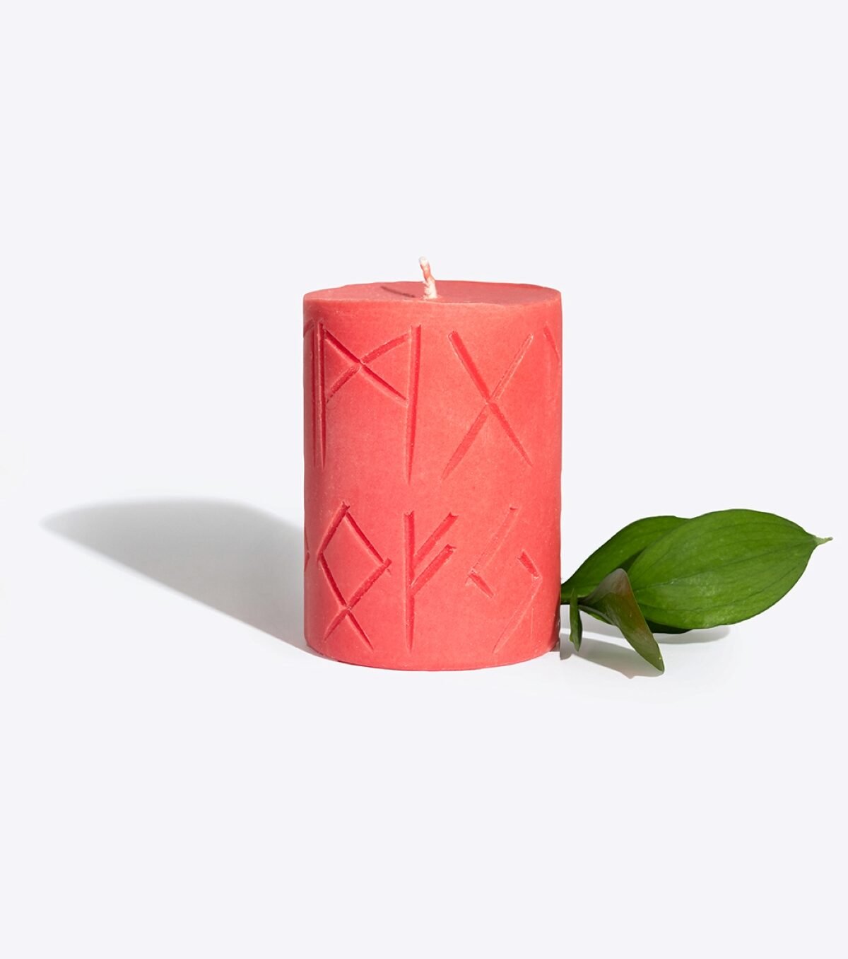 2. Smells Like Spells Rune Candle FREYA in red soy wax with runic carvings, styled with green leaf