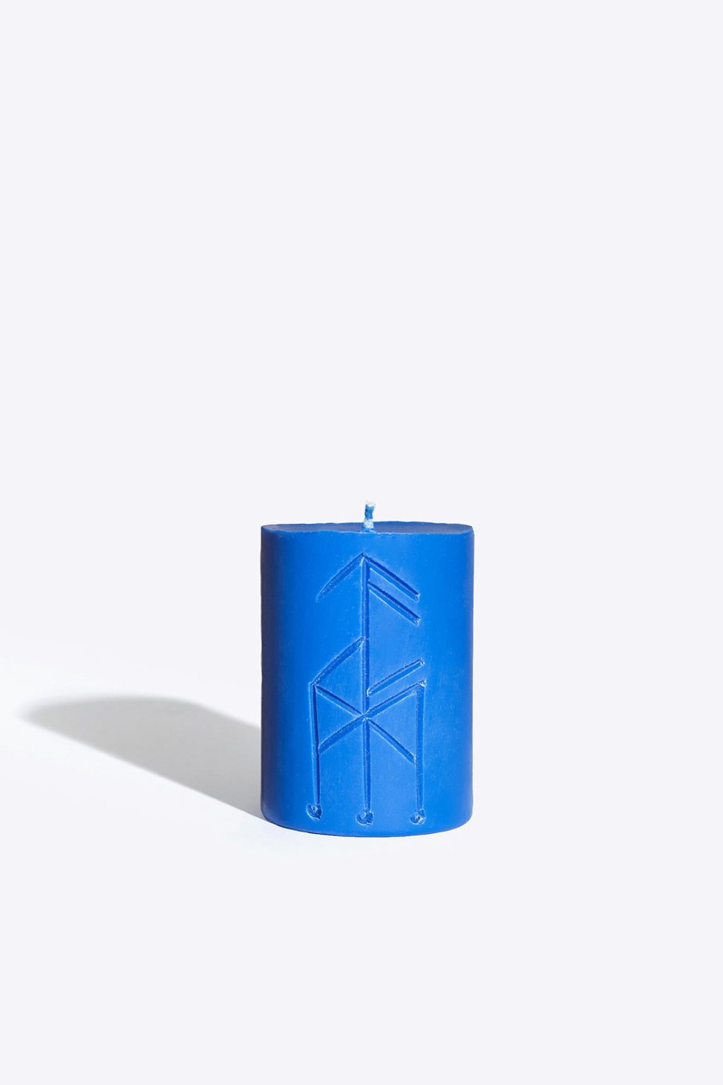 3. Smells Like Spells Rune candle THOR in blue, close-up of rune design, studio setting