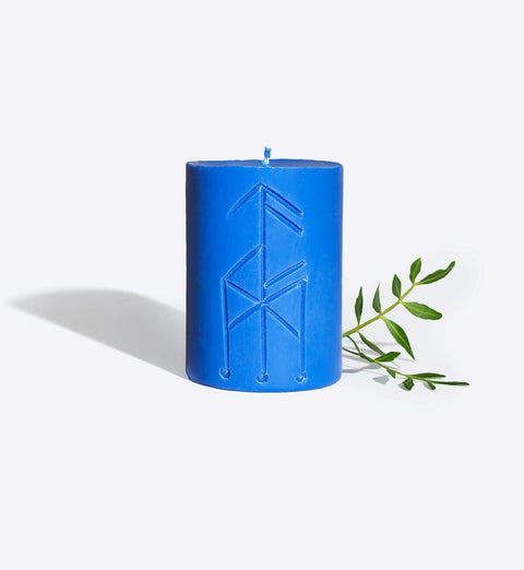2. Smells Like Spells Rune candle THOR in blue, featuring rune design with green leaf accent, studio setting