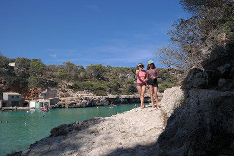 1. Two women enjoying a sunny day by the beach, one wearing Smarttan's Tan-Through Mini Leggings in Blue Mandala