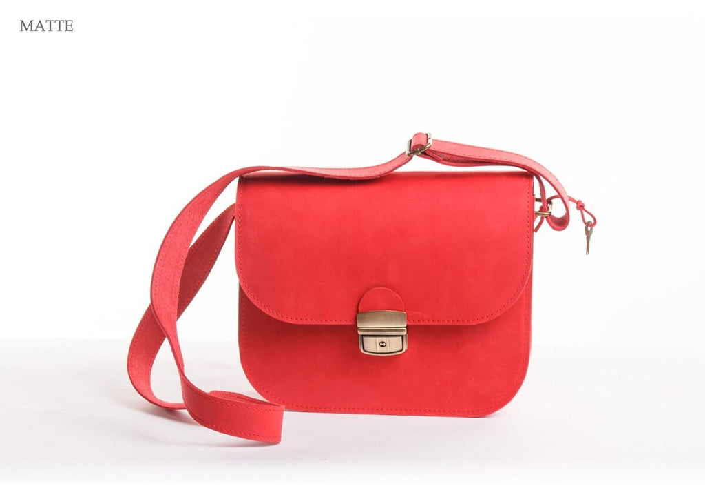 2. Zelma Kraft red matte natural leather saddle bag with adjustable strap and buckle closure in studio setting