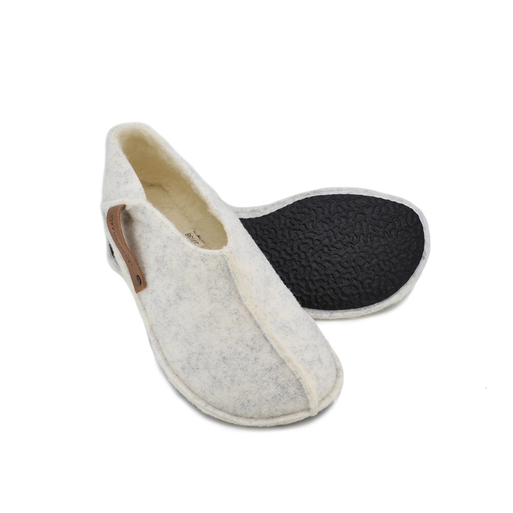 4. Studio image of Tohkri unisex slippers in white lambswool showing flexible rubber sole