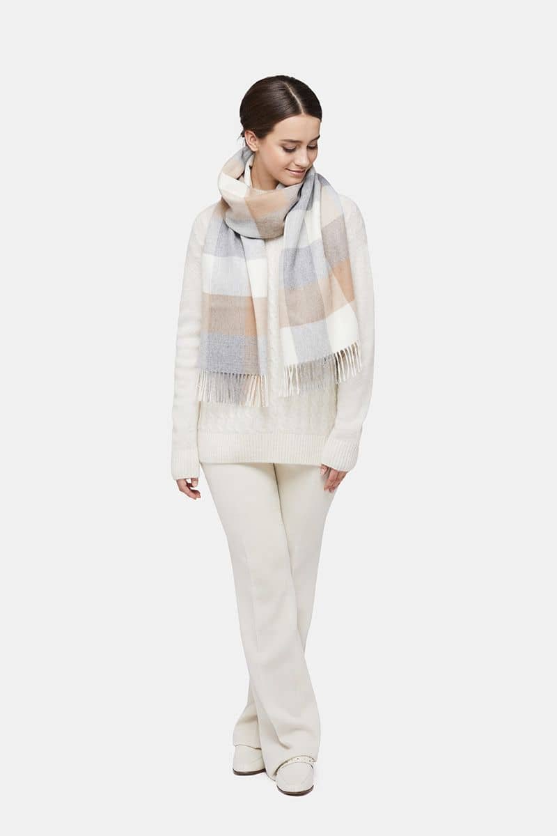 1. Women's natural baby alpaca wool check scarf in gold and grey, worn by model in lifestyle setting