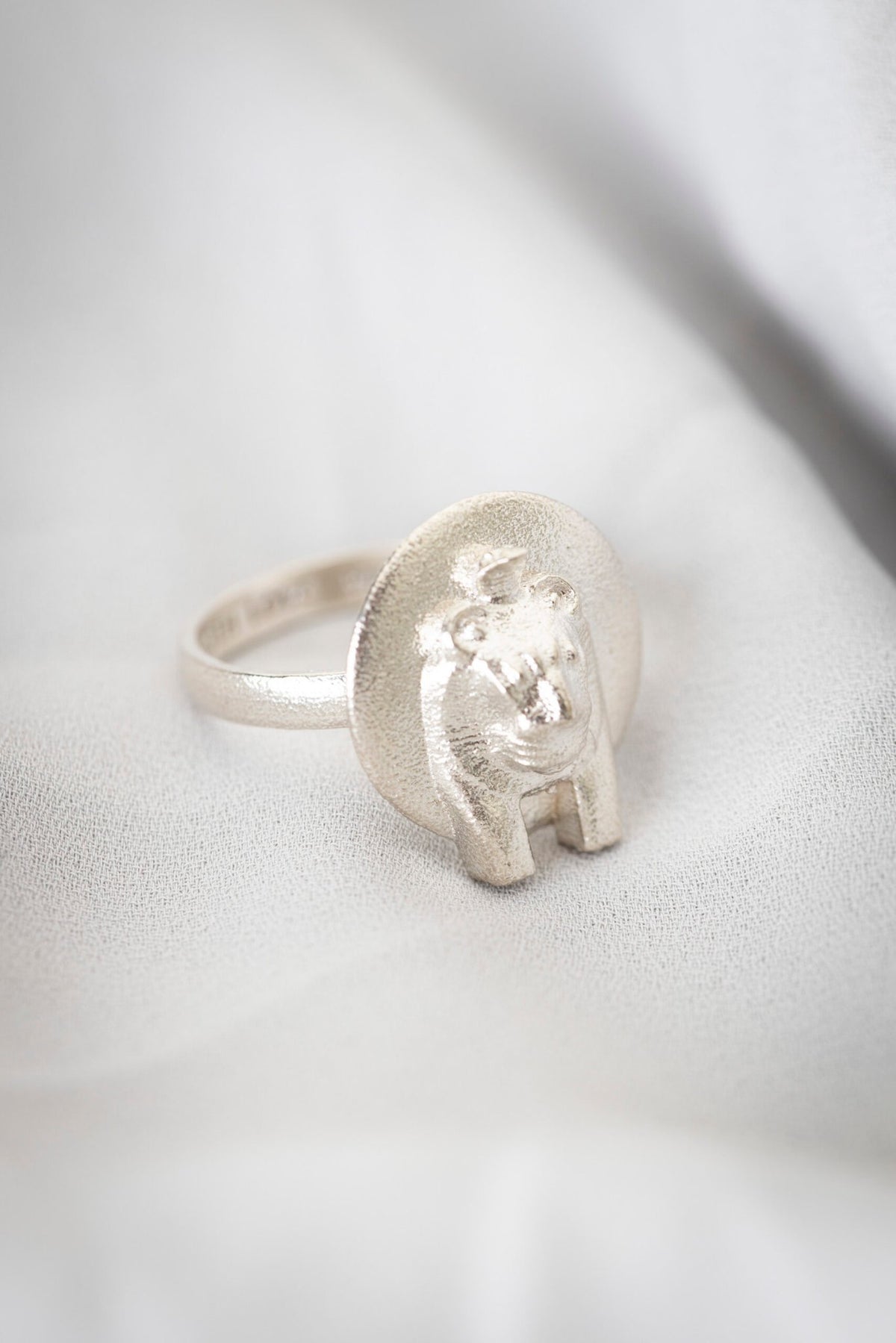 1. Sekhmet Fire Necklace Ring in ethical 925 silver, handcrafted in Estonia, shown on a soft fabric background