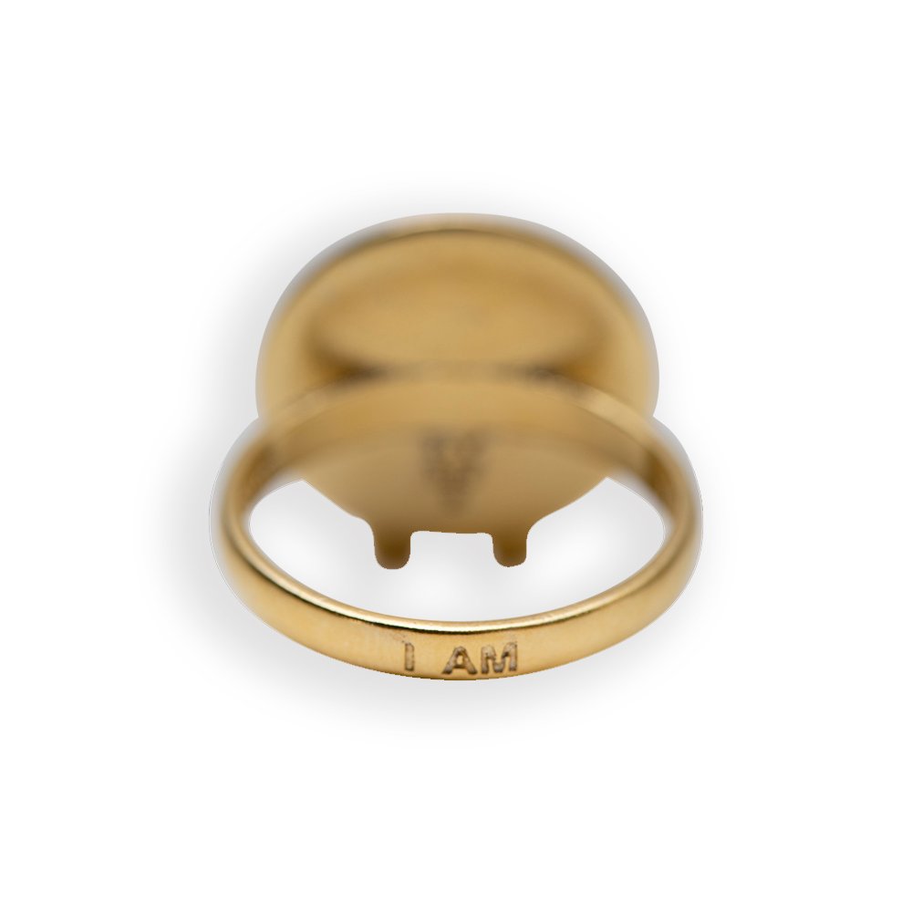 6. Close-up of Sekhmet Fire Necklace Ring in gold by New Vintage by Kriss, displaying engraved text 'I AM'