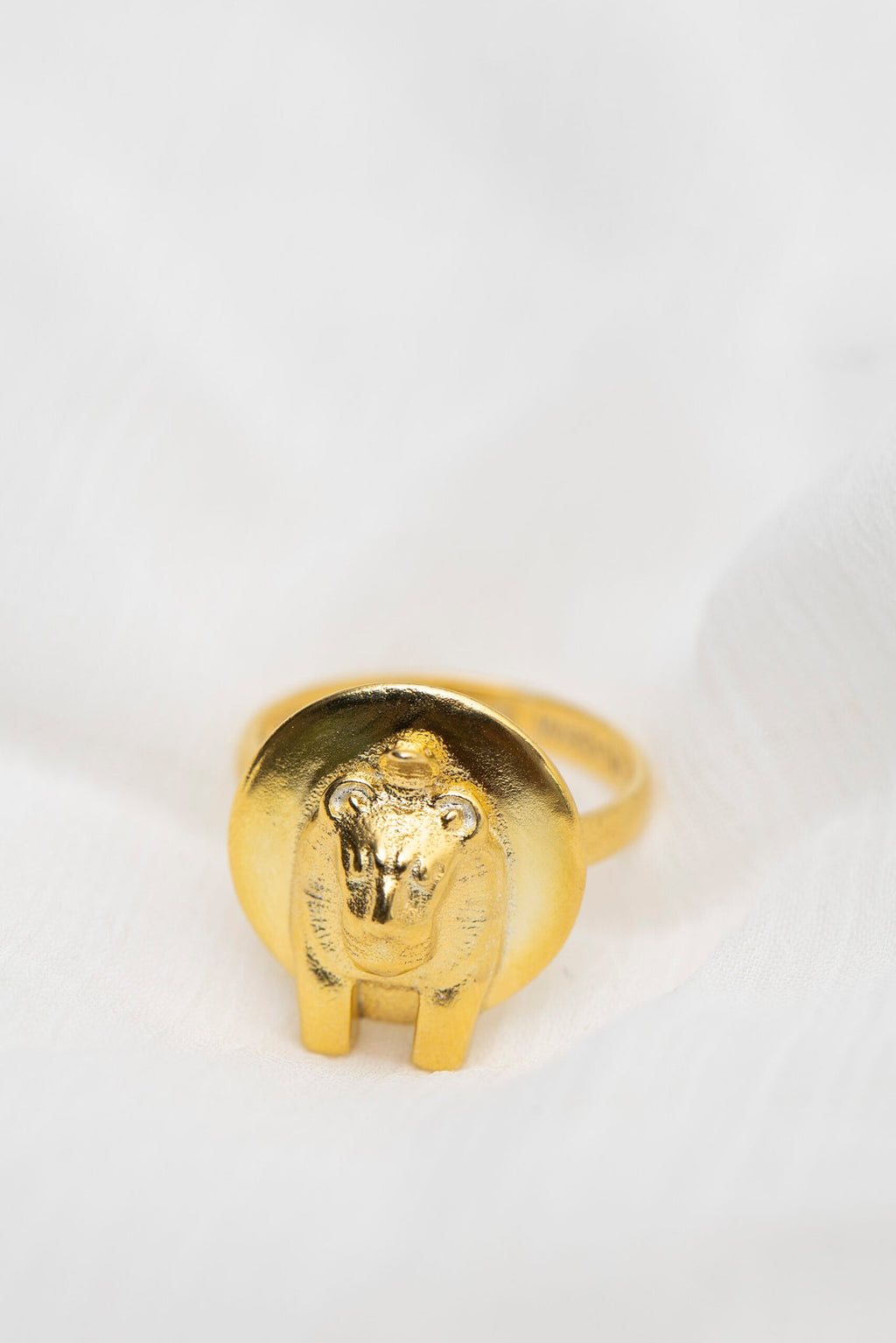 3. Studio shot of Sekhmet Fire Necklace Ring in gold by New Vintage by Kriss, featuring lion-headed design on white fabric