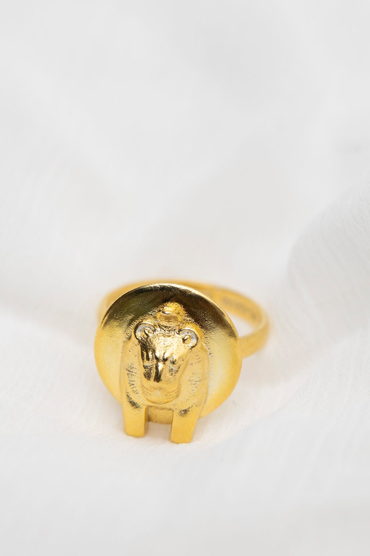 3. Studio shot of Sekhmet Fire Necklace Ring in gold by New Vintage by Kriss, featuring lion-headed design on white fabric
