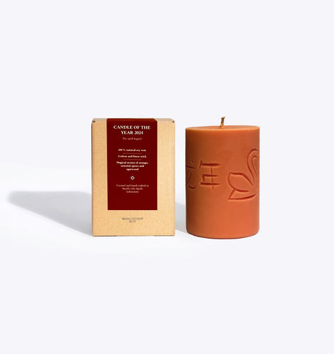 1. Smells Like Spells Candle of the Year 2024 with engraved symbols, shown with packaging in studio setting